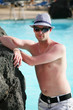 Foto: Porträt einer schönen jungen Mann in den Pool mit Hut Porträt einer schönen jungen Mann in den Pool mit Hut