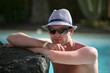 Foto: Porträt einer schönen jungen Mann in den Pool mit Hut Porträt einer schönen jungen Mann in den Pool mit Hut