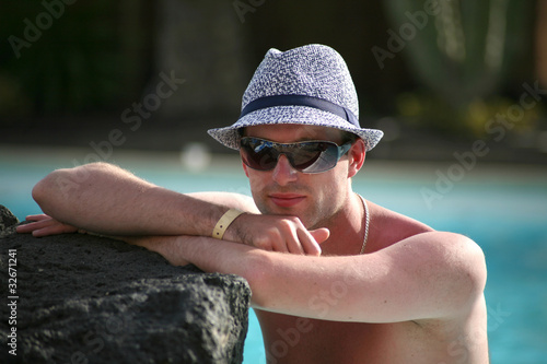 Foto: Porträt einer schönen jungen Mann in den Pool mit Hut Porträt einer schönen jungen Mann in den Pool mit Hut