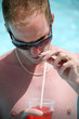 Foto: Porträt eines jungen Mannes in den Pool mit einem Cocktail Porträt eines jungen Mannes in den Pool mit einem Cocktail