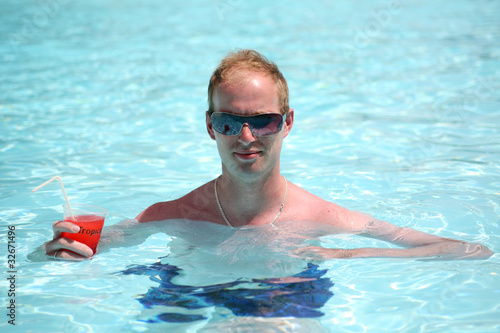 Foto: Porträt eines jungen Mannes in den Pool mit einem Cocktail Porträt eines jungen Mannes in den Pool mit einem Cocktail