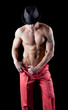 athletic man posing nude in dark with hat