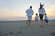 happy young family have fun on beach at sunset