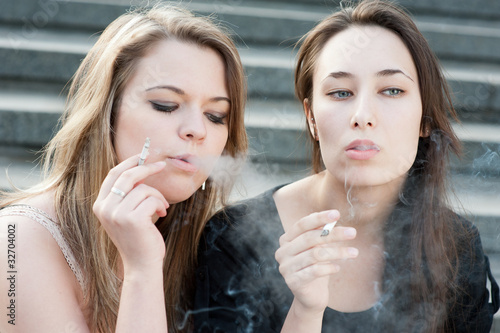 Photo: Two sad young girls smoke Two sad young girls smoke