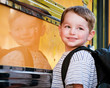 Young boy with nervous smile waits to board school bus Young boy with nervous smile waits to board school bus