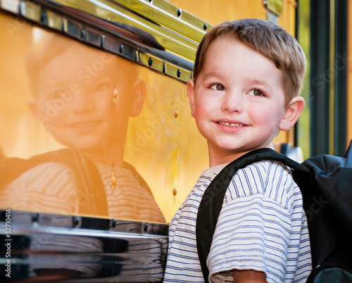 Photo: Young boy with nervous smile waits to board school bus Young boy with nervous smile waits to board school bus