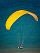 Parapentiste seul à voile jaune sur fond marin