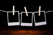 three blank instant photos on the background of a wooden table