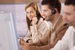 Foto: Pretty female dispatcher in call center smiling Pretty female dispatcher in call center smiling