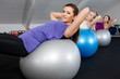 Attractive young women doing sit ups at a fitness club