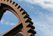 Old industrial gear segment against the blue sky