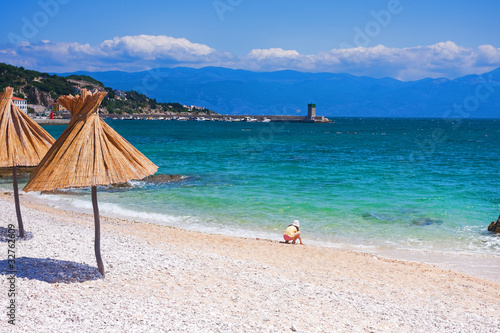 Photo: straw gamps lined up on the shingly beach in Baska, Croatia straw gamps lined up on the shingly beach in Baska, Croatia