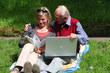 Foto: Alter Mann und junge Frau mit Laptop und Büchern im Grünen Alter Mann und junge Frau mit Laptop und Büchern im Grünen