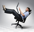 Businessman with laptop falls from an office chair, concept Businessman with laptop falls from an office chair, concept