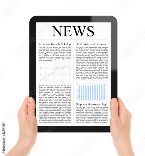 Photo: Reading News on Tablet PC with clipping path Reading News on Tablet PC with clipping path