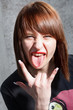 close up portrait of cool young girl showing her tongue and rock