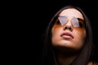 close-up portrait of sexy woman in sunglasses over dark backgrou