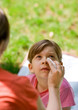 mother wiping daughter's eye with a tissue