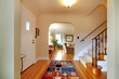 Hallway with large staircase and dinign room