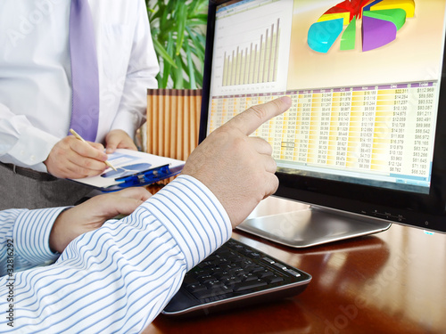 Photo: Analyzing financial data and charts on computer screen. Analyzing financial data and charts on computer screen.