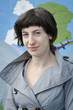 Attractive young woman in grey jacket looking at camera