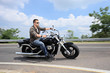 Young man riding a motorcycle on an open road