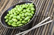 Edamame soy beans in a brown ceramic dish