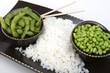 Edamame soy beans with white rice in a brown ceramic dish