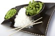 Edamame soy beans with white rice in a brown ceramic dish