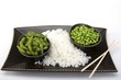 Edamame soy beans with white rice in a brown ceramic dish