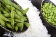 Edamame soy beans with white rice in a brown ceramic dish