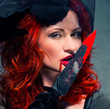 Foto: Gorgeous redhead woman with bloody knife in her hand close-up Gorgeous redhead woman with bloody knife in her hand close-up