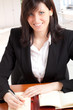 Smiling businesswoman writing on her agenda