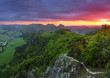 Green forest mountain at sunset with sun