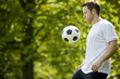 A young man playing with a football