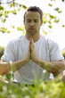 A young man meditating outdoors