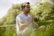 A young man meditating outdoors