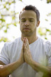 A young man meditating outdoors