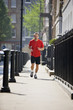 A young man jogging in the street, listening to music