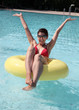 Foto: Junge Frau sitzt im Schwimmreife und hat Spass Junge Frau sitzt im Schwimmreife und hat Spass