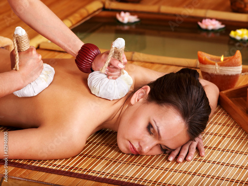 Photo: Woman getting massage in bamboo spa. Woman getting massage in bamboo spa.