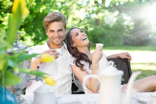 Foto: Young couple enjoying lunch in the garden Young couple enjoying lunch in the garden