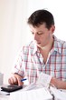 Man holding receipt while making tax computation
