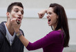 Enraged young woman about to punch her boyfriend