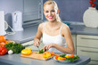 Young happy woman making salad at domestic kitchen