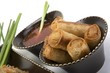 Egg rolls and sweet and sour sauce in a ceramic bowl