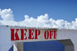 keep off sign, with sky and ocean behind keep off sign, with sky and ocean behind