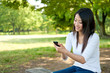 beautiful asian woman using smartphone in the park