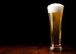 Beer into glass on a black and wooden table Beer into glass on a black and wooden table