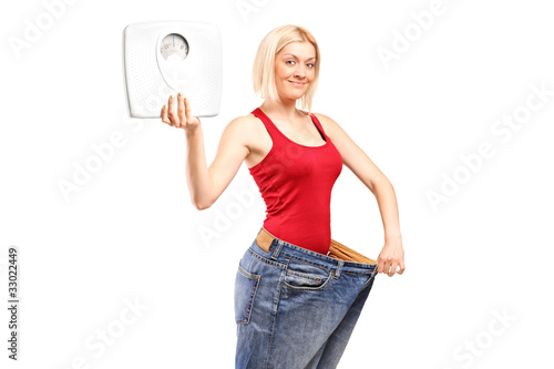 Photo: Portrait of a weight loss female holding a weight scale Portrait of a weight loss female holding a weight scale